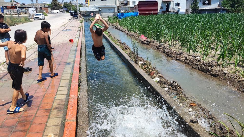 Adana'da çocukların kanal keyfi: Kaldırım plaja döndü