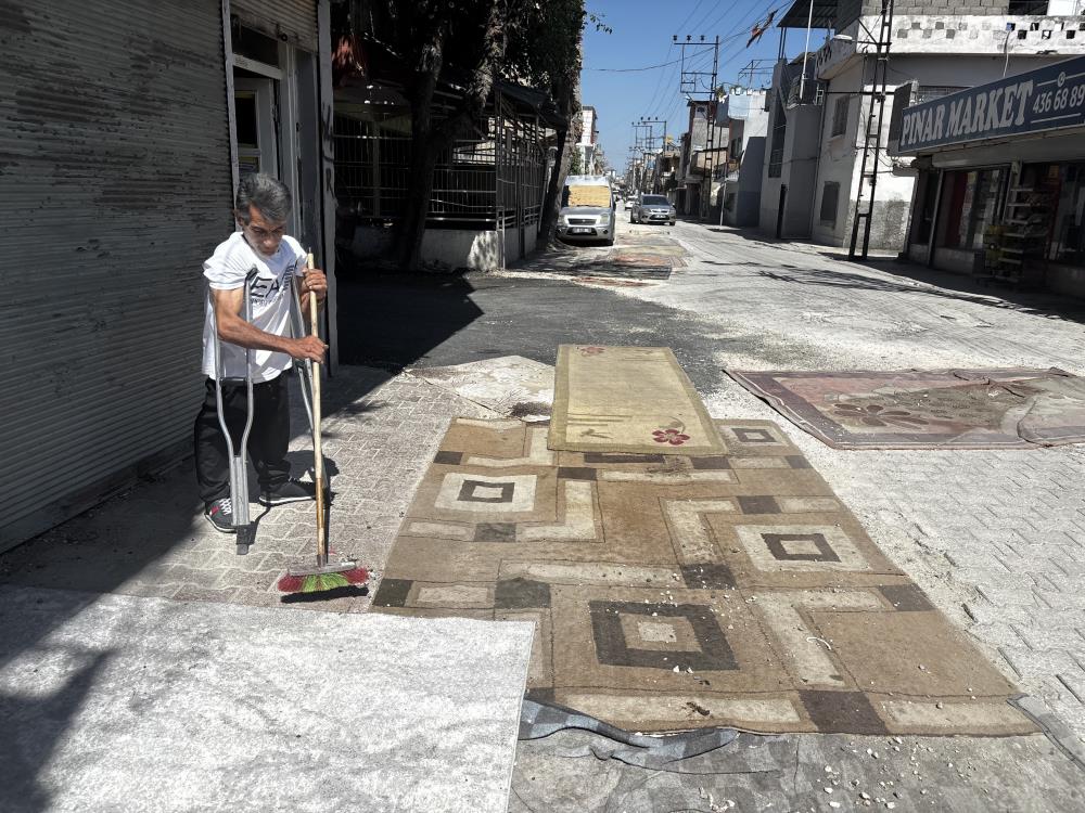 Tozdan bunalan mahalleli çareyi sokağa halı sermekte buldu
